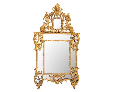 A French Regence carved giltwood marginal wall mirror:, with shaped domed cresting with mask, eagle and scrolling acanthus le
