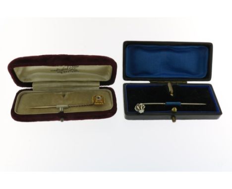  Twee gouden reversspelden, één met briljant geslepen diamant, c.  0,15 ct, en één met divers geslepen diamanten en robijnt,