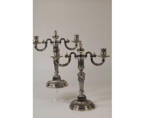   Twee verzilverde tweelichts kandelaars. Top demontabel tot  eenlichts kandelaar. Hoogte 31 cm.        Two silver plated two