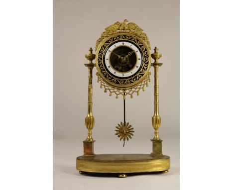   Bronzen skelet pendule bekroond met adelaar en vruchten, emaille  wijzerplaat met ajour buitenrand op 2 kolompoten uitlopen