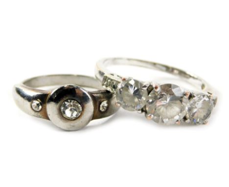 Two dress rings, comprising a three stone dress ring, on brushed white metal colouring and a further expanding dress ring in 