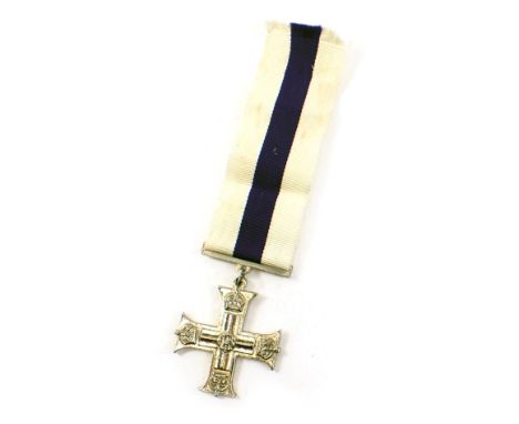 A replica base metal military cross, with modern ribbon. 