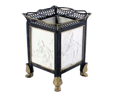 A 19thC German porcelain tea light holder, with ebonised and gilt metal mounts set with four lithophane panels depicting chil