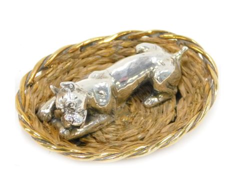 A 20thC silver miniature model of a dog in a basket, with woven sides, indistinct makers stamp, stamped 925 to underside, 6cm