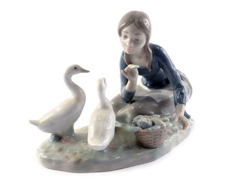 A Lladro porcelain model of a lady feeding geese, on oval base, 23cm wide, boxed.