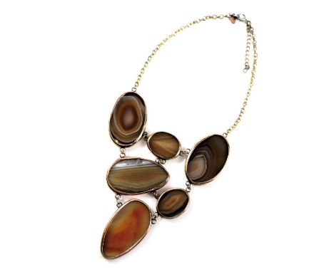 A Jaeger semi precious stone set fashion necklace, the pendant section set with orange agate slices, in a rubbed yellow metal