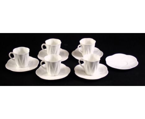 A Shelley white glazed part coffee set, comprising five cups, six saucers, each with stylised shell decoration.  