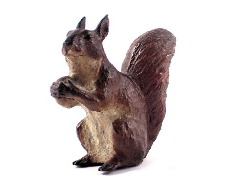 A cast metal figure of a seated squirrel, carrying nut, 7cm high. 