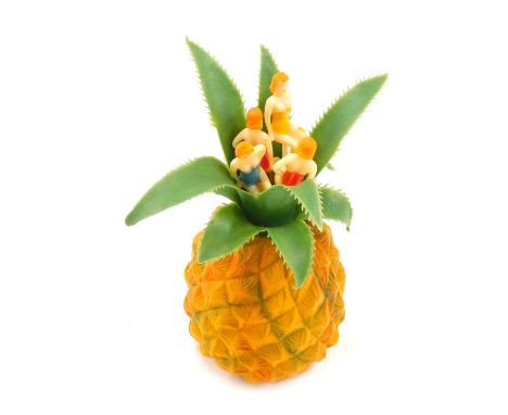 A mid-century novelty plastic cocktail stick holder, modelled in the form of a pineapple, holding four cocktail sticks each w