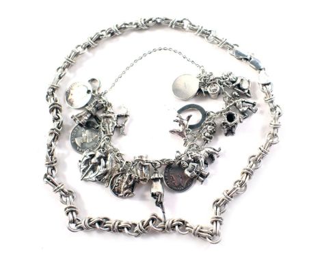 A charm bracelet, on curb link bracelet with coin and figure drops, stamped 925, and a fancy link chain, white metal stamped 