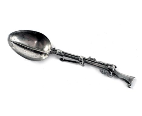 A novelty rifle teaspoon, the handle formed as a rifle, white metal unmarked, 10cm wide. 