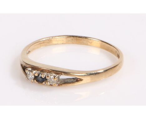 9 carat gold ring, the shank divides to either side of the head which is set with a central sapphire and diamond to either si