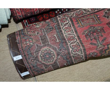 Middle Eastern carpet, the puce ground with white and red scroll and foliate pattern centre surrounded by multiple borders an