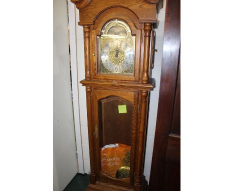 20th Century oak cased longcase clock, the hood with scroll carved pediment and arched bevelled glazed door, the dial with mo