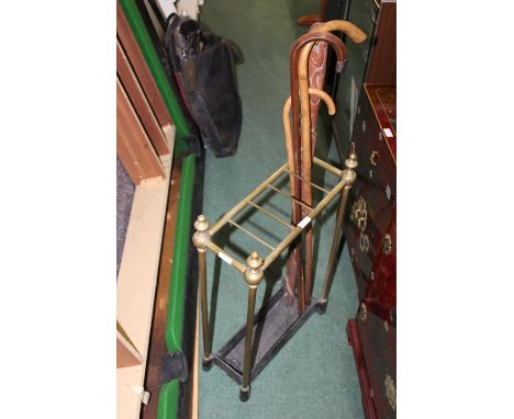 Edwardian brass stick stand, with shaped finials above five divides and a tray base, together with four walking sticks (5)