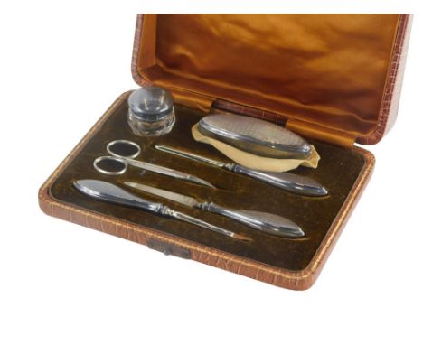 A George V silver mounted manicure set, with engine turned decoration, to include silver handled nail file, cuticle pusher, s