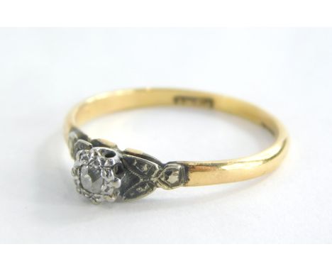 A diamond dress ring, with central illusion set tiny diamond, with V splayed platinum shoulders on a yellow metal band stampe