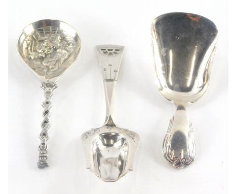A silver caddy spoon, the handle cast with scrolls, and two further small spoons, the bowl of one cast with a tavern scene.  