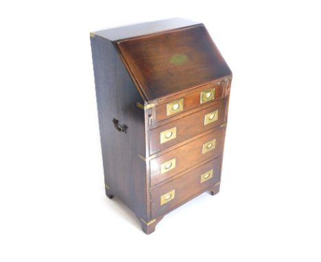 A small mahogany and brass bound campaign style bureau, the fall enclosing a fitted interior above four drawers, each with re