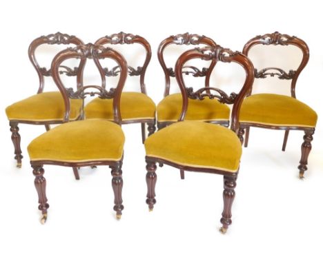 A set of six early Victorian mahogany balloon back chairs, each with a shaped carved and pierced back, a padded seat on turne