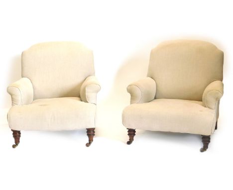 A pair of Victorian walnut Howard type armchairs, each upholstered in beige fabric and turned legs with ceramic castors, numb