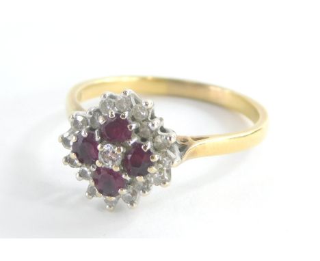 An 18ct gold ruby and diamond cluster ring, the central floral cluster set with four oval cut rubies and central tiny diamond