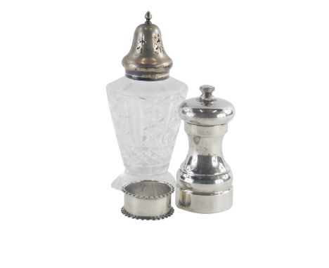 A 20thC silver pepper grinder, of plain form, marked 925 to base, a cut glass and silver topped sugar sifter, and a silver na