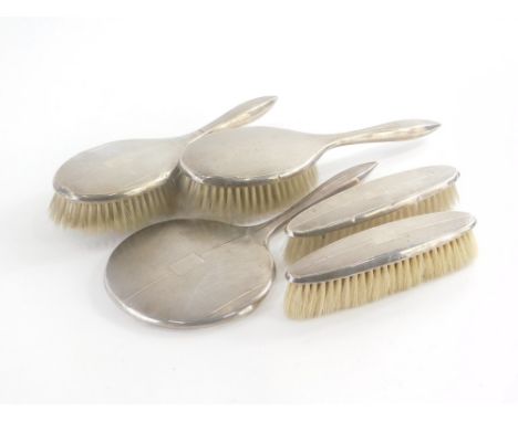 A George VI silver mounted brush set, to include two hairbrushes, two clothes brushes and a hand mirror, with engine turned d