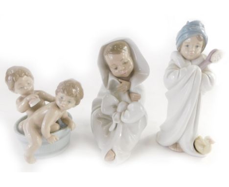 Three Spanish porcelain figures, a Lladro figure of a child with a brush, and a duckling, a figure of two children bathing in