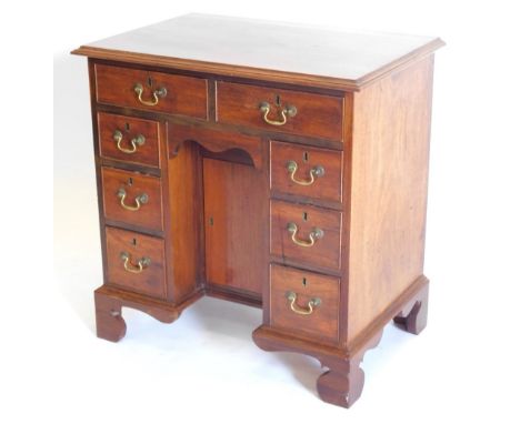 A mahogany kneehole desk in George III style, the rectangular top with a moulded edge above an arrangement of eight drawers a