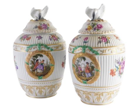 A pair of late 19th /early 20thC Berlin porcelain vases and covers, within laurel leaves, flower sprays, etc., with ribbed bo