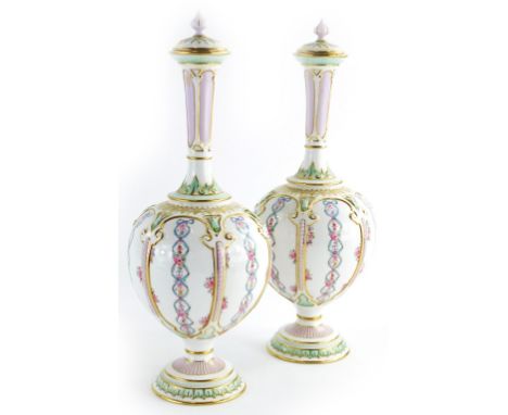 A pair of Royal Worcester porcelain bottle shaped vases and covers, each decorated with flowers, ribbons, etc., within compar