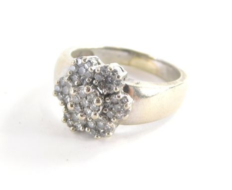 A diamond cluster ring, with six petal flower design, each set with seven round brilliant cut tiny diamonds in claw setting o