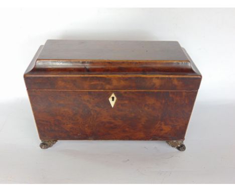 A Georgian burr walnut and boxwood inlaid sarcophagus tea caddy, the hinged lid enclosing a part fitted interior upon three c