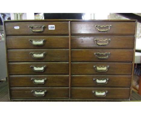 A vintage nest of twelve index filing drawers in oak, presented as side by side arrangement of six drawers