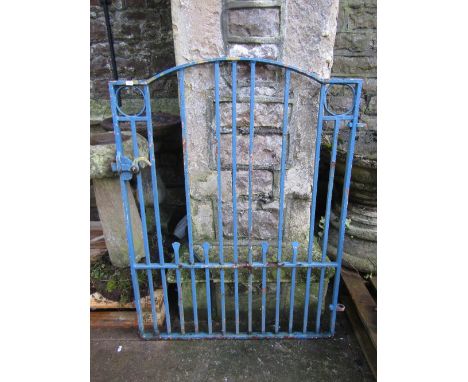 A cast iron pedestrian gate of slightly arched form with vertical bars, simple latch and blue painted finish, 90 cm wide appr
