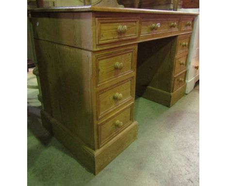 A stripped pine kneehole twin pedestal desk fitted with an arrangement of nine drawers set on plinths, 4 ft wide x 2ft deep a