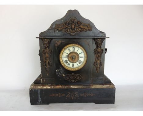 A 19th century black slate mantle clock of architectural form fitted with cast metal maiden heads and cherubs, fitted with a 