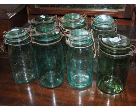 Seven vintage Solidex green glass storage jars together with a wooden crate