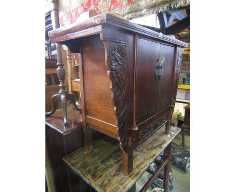 A vintage Chinese stained/lacquered pine and elm side cupboard enclosed by a pair of doors, flanked by carved foliate panels,