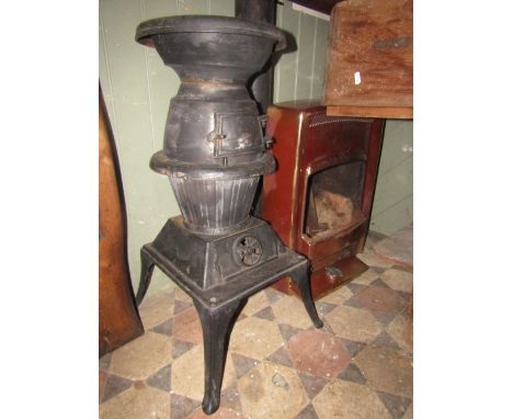 A cast iron potbelly stove, raised on rectangular platform and four swept supports, together with a section of flue pipe and 