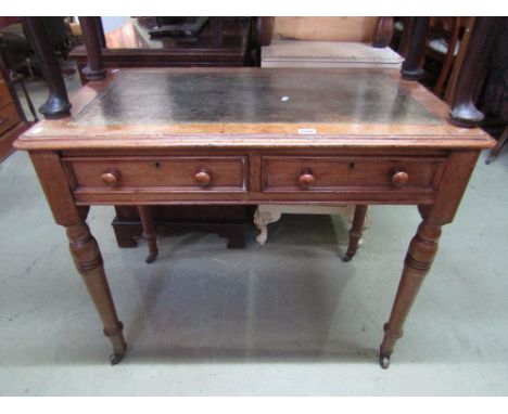 A Victorian mahogany writing table with inset green leather panelled top over two frieze drawers raised on turned tapered leg