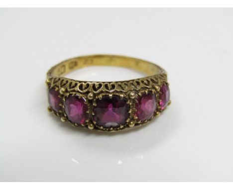 A Victorian 18ct ruby ring set with five graduating claw set stones, in pierced and engraved mount, 3.5g