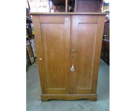 A vintage stripped and waxed side cupboard, freestanding and enclosed by a pair of full length rectangular panelled doors, th