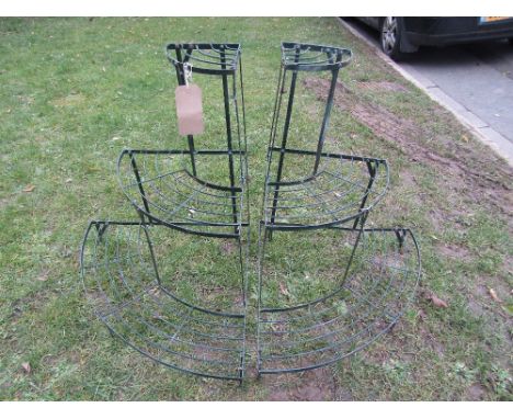 A pair of contemporary green painted light steel three tier graduated corner plant stands with wire treads
