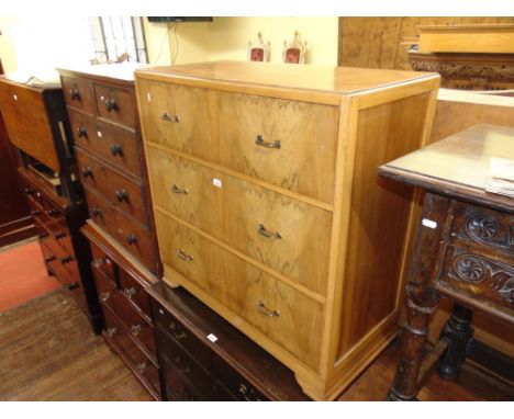 An Art Deco pale walnut chest of three long drawers on short bracket supports, 93 cm wide approx.