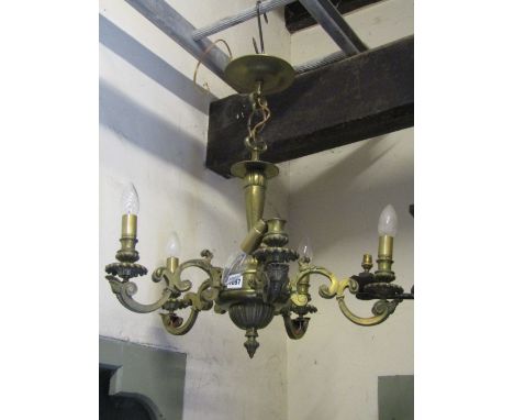 A heavy cast brass hanging ceiling light with pierced gothic trefoil fitting and moulded stem supporting five scrolling acant