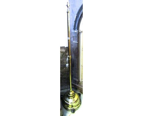 A polished brass lamp standard on circular and weighted base