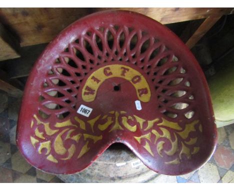 A vintage Victor saddle shaped cast iron tractor/implement seat with decorative pierced detail and later painted finish