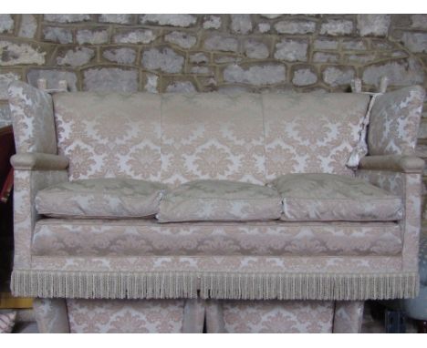 A Knoll type two to three seat sofa with drop wings and tassel tie backs, beige ground with floral pattern upholstery and tas